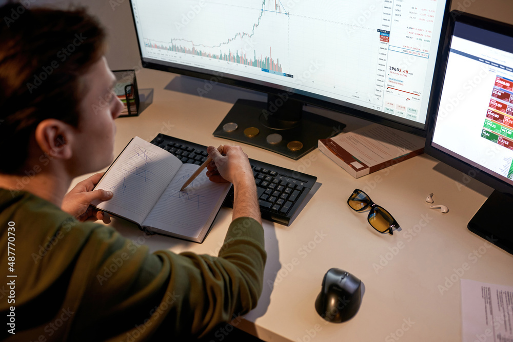 Fototapeta premium Trader watch and draw business graph in notebook