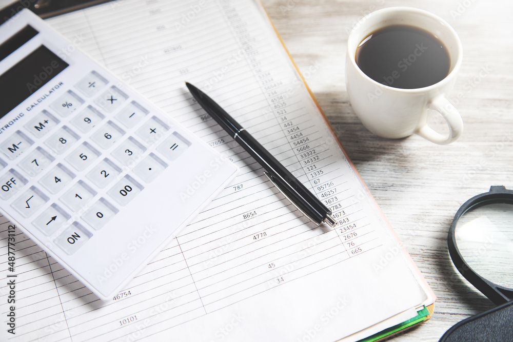 calculator with coffee and magnifier on document calculator with coffee and magnifier on document