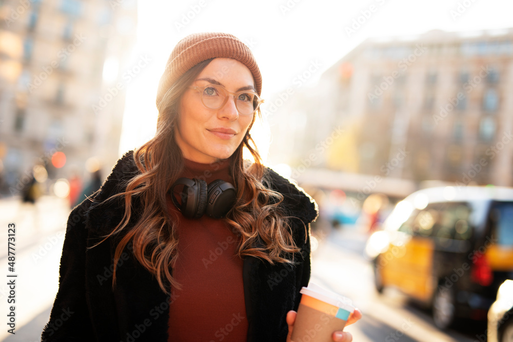 Pretty girl listening music with her headphones. Beautiful woman enjoy in sunny day..