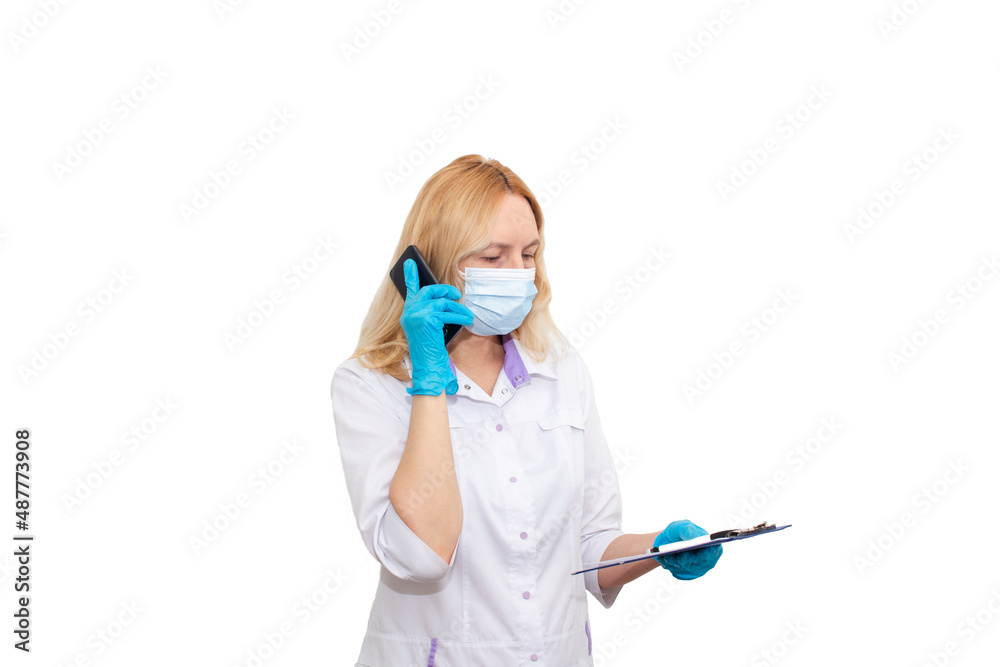 Cheerful young female doctor in mask and gloves talking on mobile phone looking at camera isolated on white Cheerful young female doctor in mask and gloves talking on mobile phone looking at camera isolated on white
