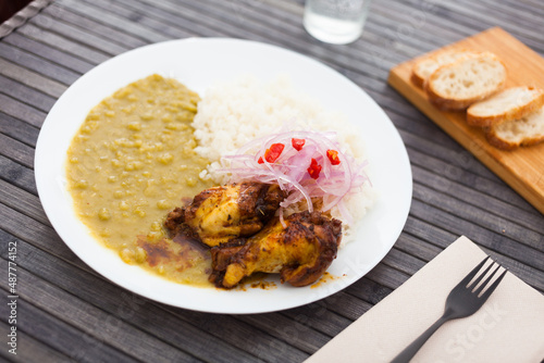 chicken wings with mashed peas, rice and pickled onions on white plate