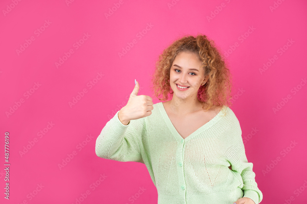 Close-up portrait of attractive surprised girl, showing thumbs up gesture. Success luck concept.