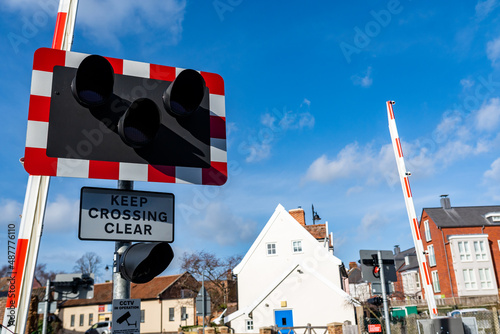 Keep crossing clear sign on a busy level crossing on the mainline to London. There are barriers and warning lights to notify the public and keep them safe while trains pass