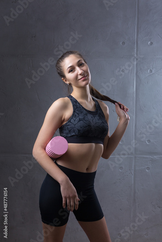 Portrait of a slender athletic young girl against a concrete wall in a fashionable apartment interior.
