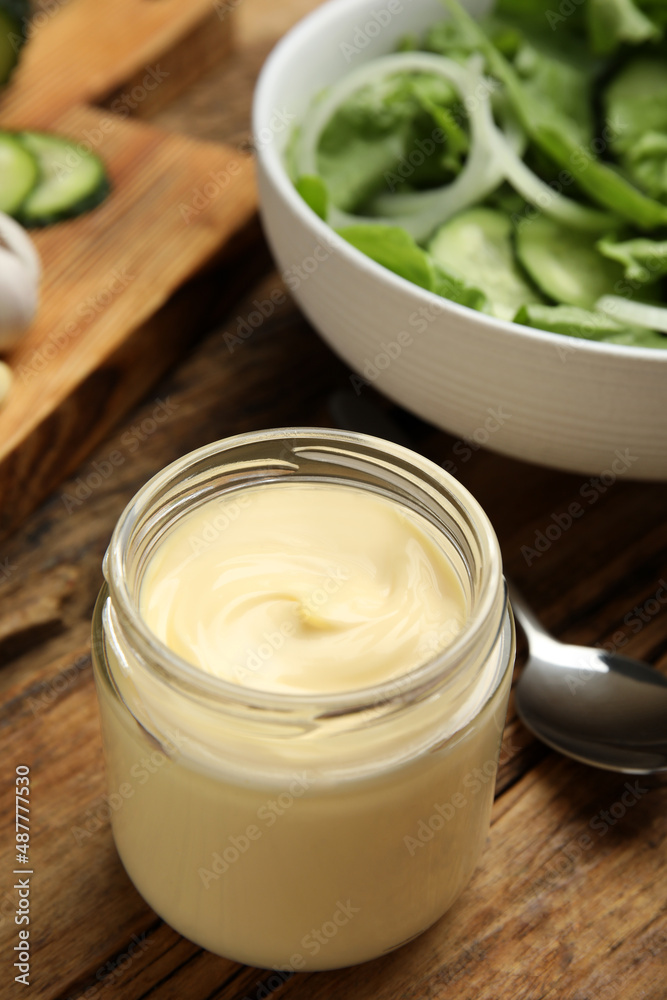 Jar of delicious mayonnaise and salad on wooden table Jar of delicious mayonnaise and salad on wooden table