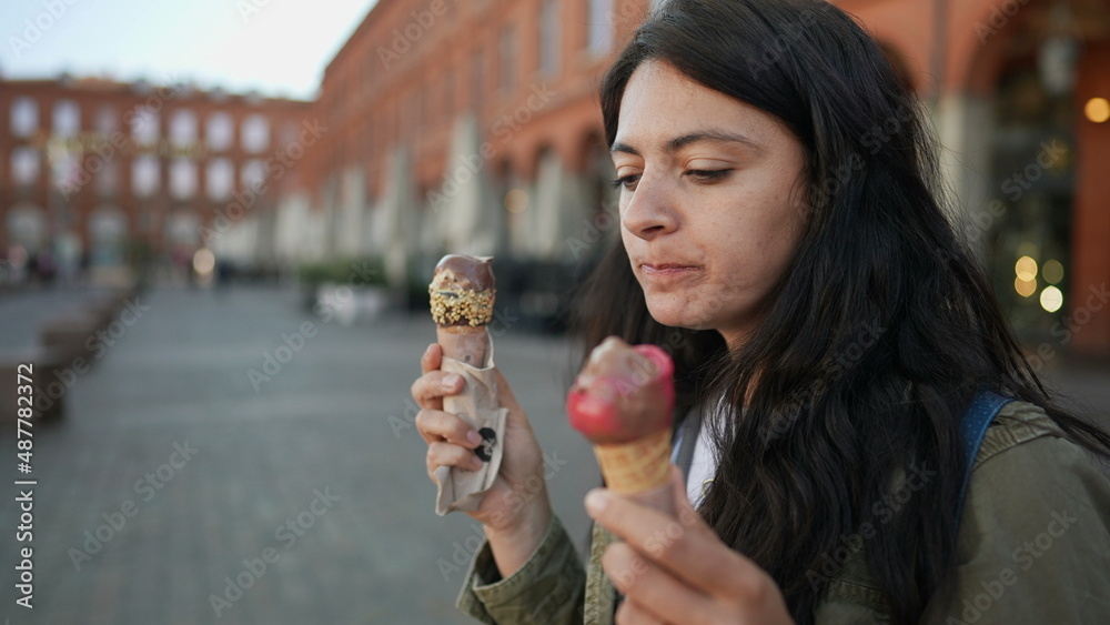Fototapeta premium Woman eating two ice creams outside in Europe