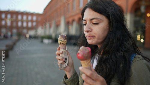 Woman eating two ice creams outside in Europe
