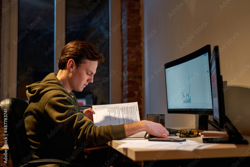 Male trader reading educational book at work Male trader reading educational book at work