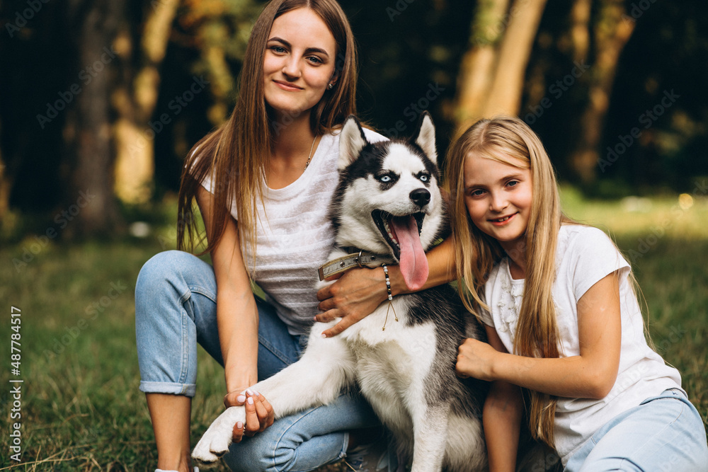 Two sisters with their dog in park