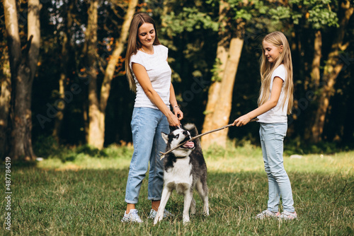 Two sisters with their dog in park © Petro