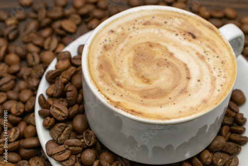 White cup of coffee with roasted beans. cup of cappuccino