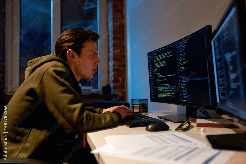 Focused IT developer watching on computer monitor