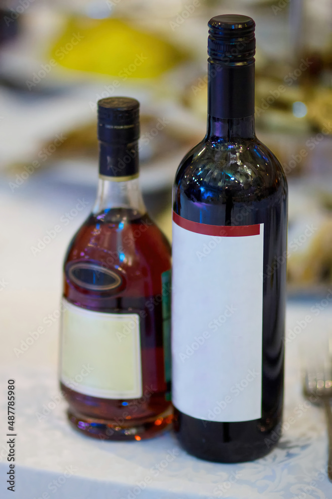 Bottles of alcoholic beverage are on the table. Wine and cognac. Bottles of alcoholic beverage are on the table. Wine and cognac.