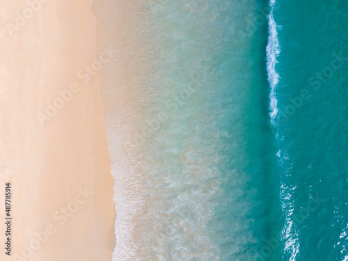 Aerial view high angle view Top-down seawater wave on sandy beach. Aerial view above beach sea in tropical beach sea.