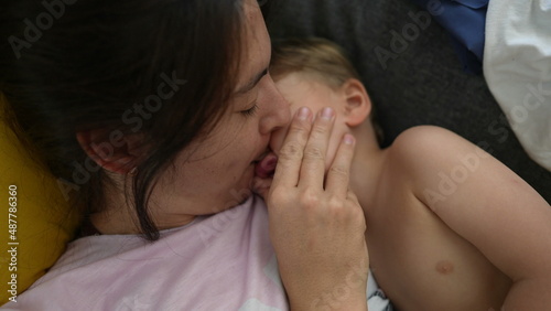 Mother kissing toddler child showing love