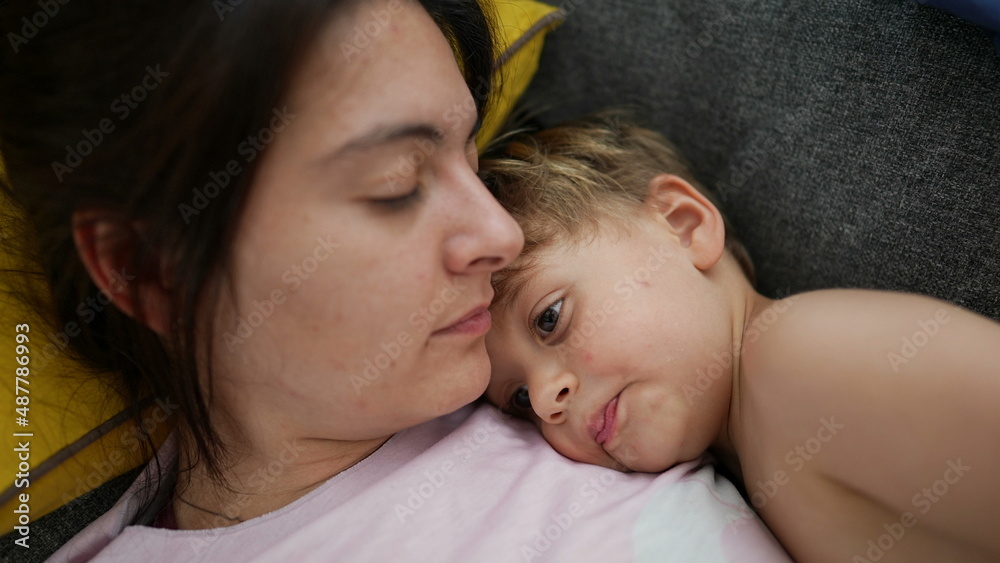 Mother and child lying on sofa resting little boy lies on couch with mom Mother and child lying on sofa resting little boy lies on couch with mom