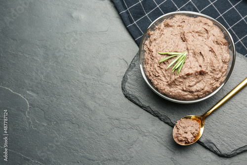 Tasty liver pate with rosemary on black table, flat lay. Space for text