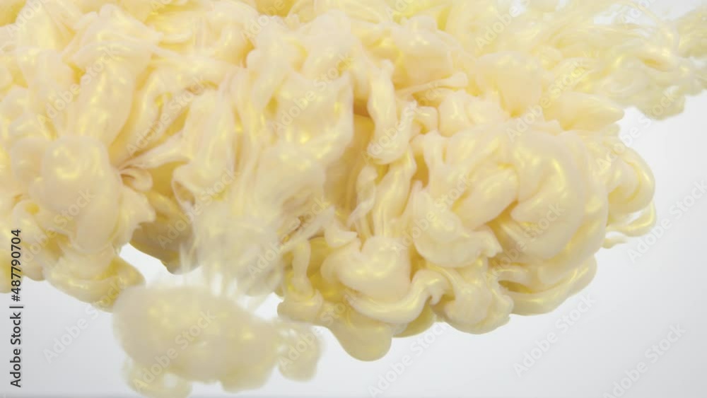 A cloud of golden colors slowly descends on a white background. A cloud of golden colors slowly descends on a white background.