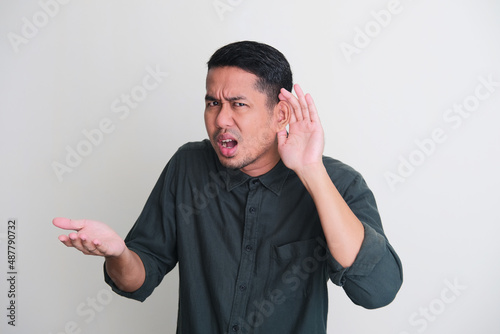 Adult Asian man showing can not hear gesture photo