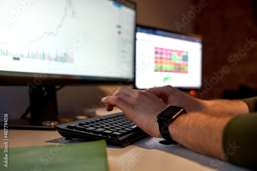 Selective focus of male trader typing on computer