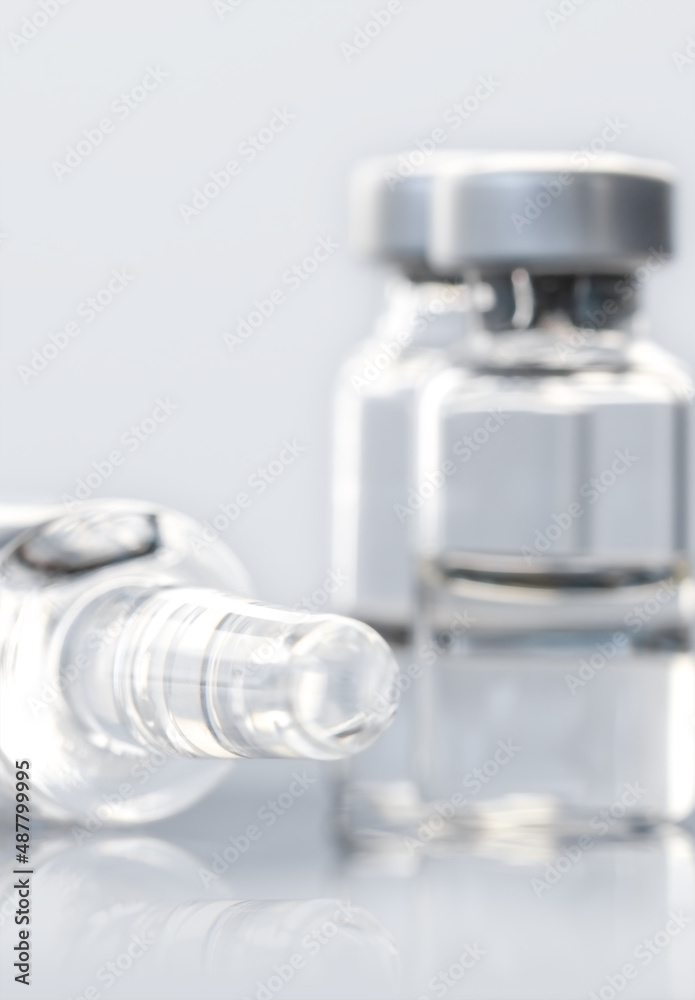 Concept of vaccine against COVID-19. Glass medical vials with liquid. Ampoules with coronavirus vaccine on a medical glass table. Selective focus Concept of vaccine against COVID-19. Glass medical vials with liquid. Ampoules with coronavirus vaccine on a medical glass table. Selective focus