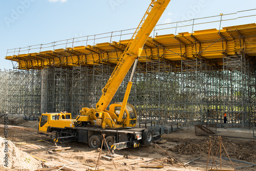 truck crane at a construction site during the day, during the construction of a transport bridge