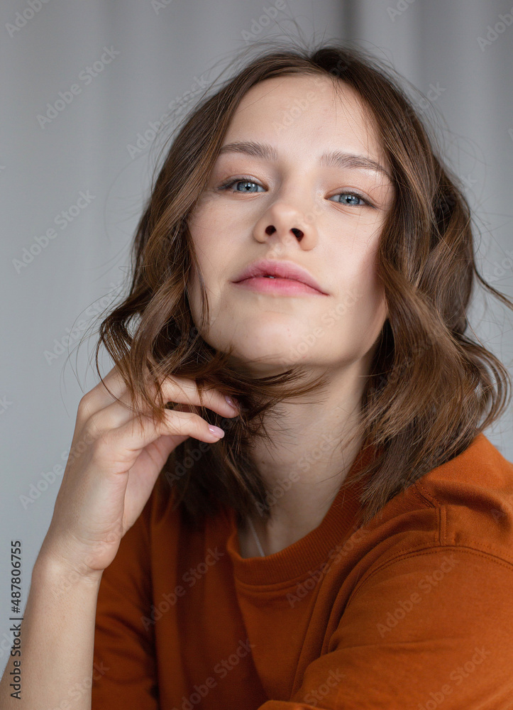 Portrait of white european young girl with brown hair with blue eyes on grey Portrait of white european young girl with brown hair with blue eyes on grey