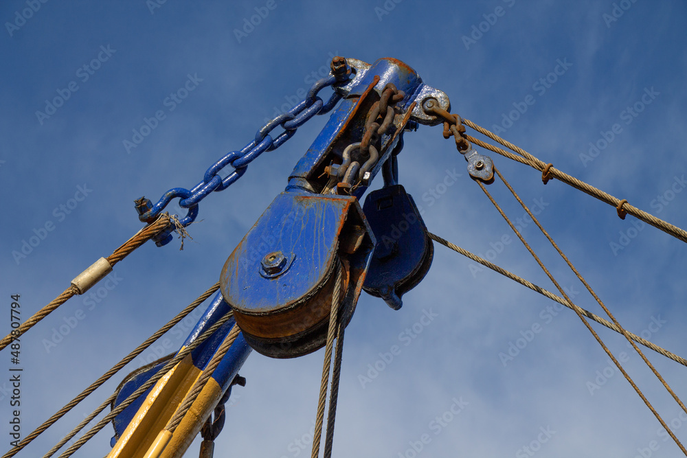 Beam Trawler trawl gear and wires hanging on its booms close up.
Beam Trawler trawl gear and wires hanging on its booms close up.