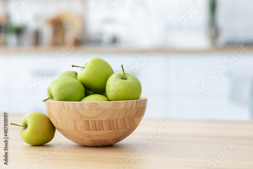 фотографія Fresh green apples in a wooden bowl on a wooden table witj copy space