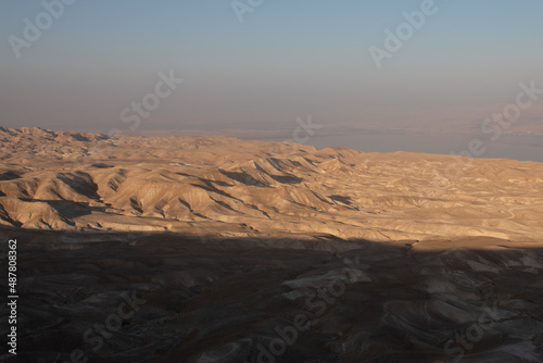 Beautiful landscape of Israeli Judean Desert mountains, with sunrise over the dry riverbed of Nahal Dragot Wadi, popular hiking trail winding between rugged rocky cliffs towards the Dead Sea. High photo