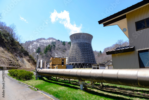 Matsukawa geothermal power plant on dry pine trees moutain on background ,big pipe generator to the plant in front house in Tohuku,Japan.