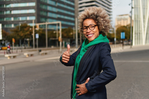 Happy successful professional posing near office building. Young African American business woman. Female business leader concept