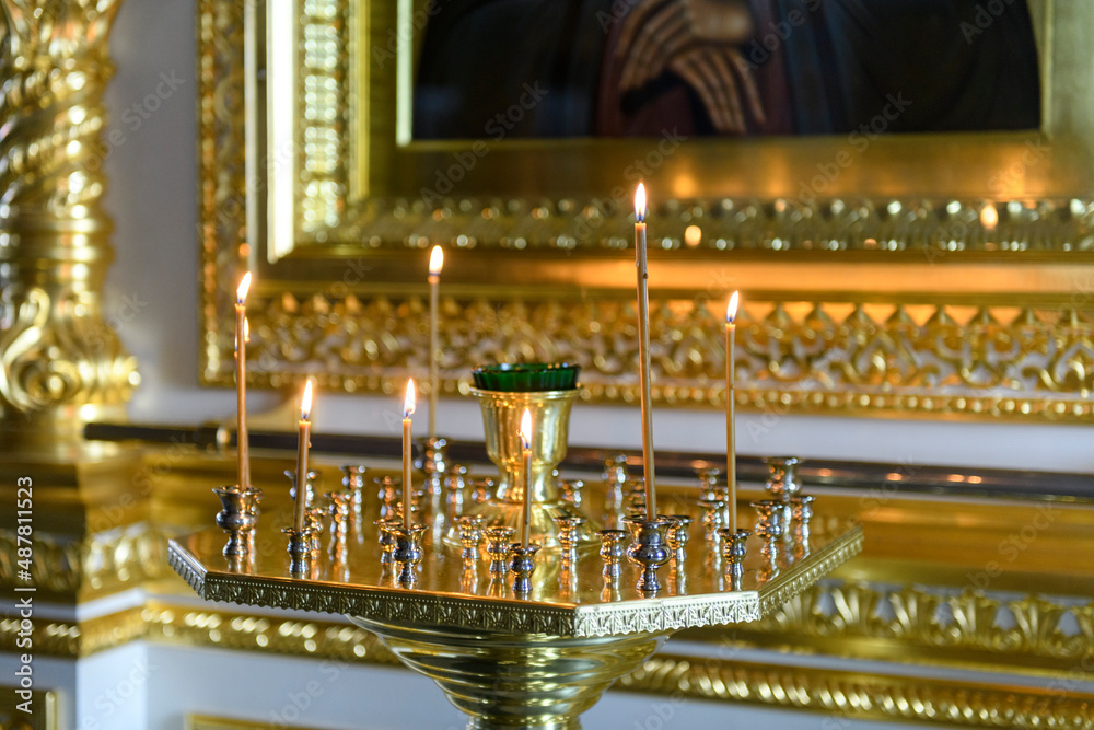 Church candles on the background of icons in Russian orthodox cathedral