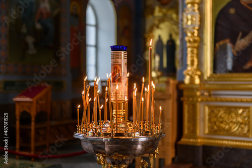 Church candles on the background of icons in Russian orthodox cathedral