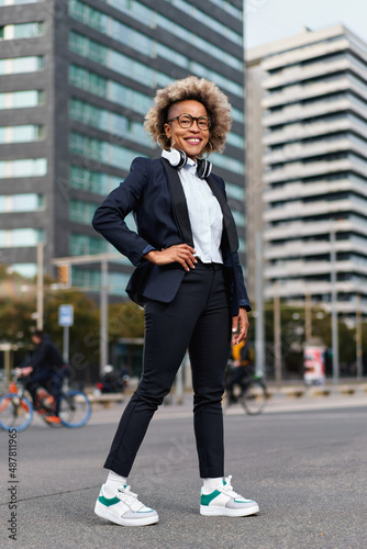 Portrait of beautiful black businesswoman wearing suit in urban background. Model of fashion with afro hairstyle.