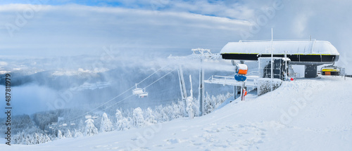 Fototapeta Naklejka Na Ścianę i Meble -  Winter landscape in the Polish mountains of the Sudetes, a ski lift on the Czarna Gora mountain, a thick layer of snow on the slope, a winter afternoon.