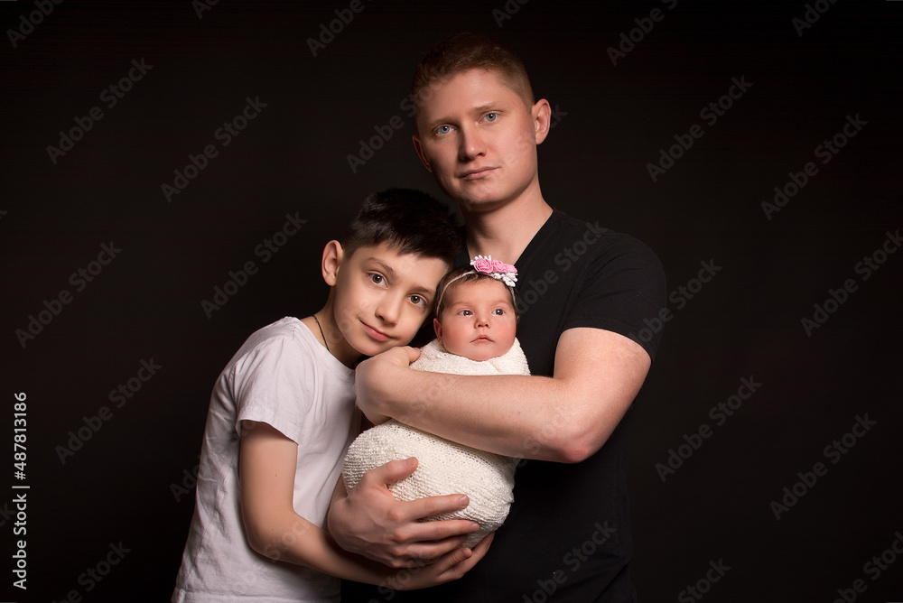 Dad, son and daughter. Close-up . Black background . Dad, son and daughter. Close-up . Black background .