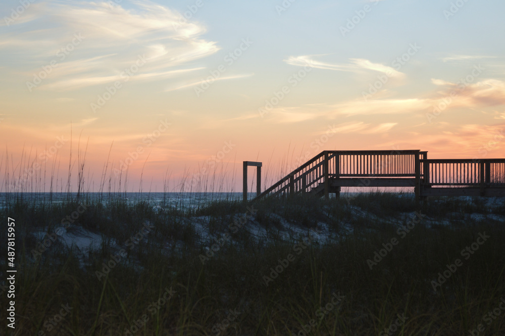 Silhouette of stairs leading down to the beach at sunset in Destin Florida