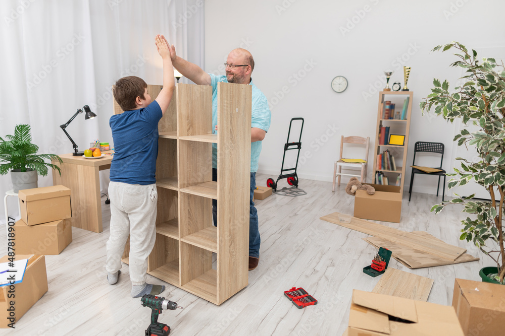 The son and father are happy as they finish assembling the bookcase ...