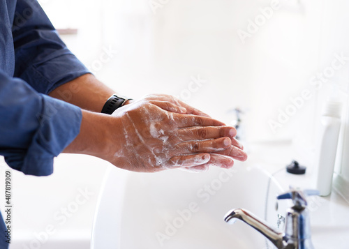 Close up shot of a businessman washing his hands in the bathroom sink