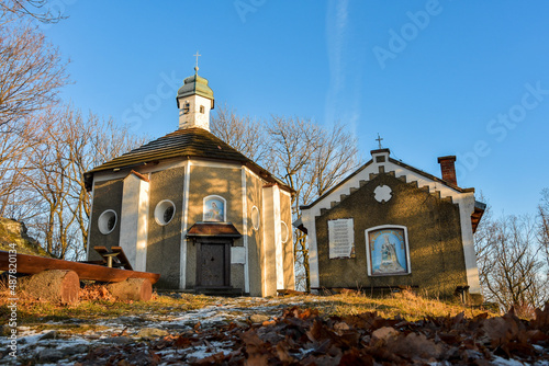 The mountain chapel of the Weeping Mother of God on the top of the mountain in the Bardzkie Mountains, view from the hiking trail at sunset.
