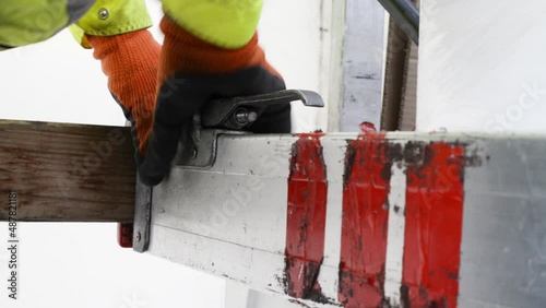 Driver secures a truck load cargo using an aluminium bar. Secure cargo fasten