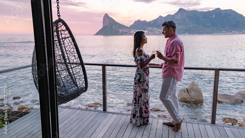 couple man and women drinking coffee during on balcony sunrise at vacation in Cape Town South Africa. 