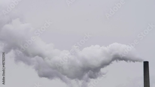 Single Factory chimney smoke on a gray day. Monochromatic.