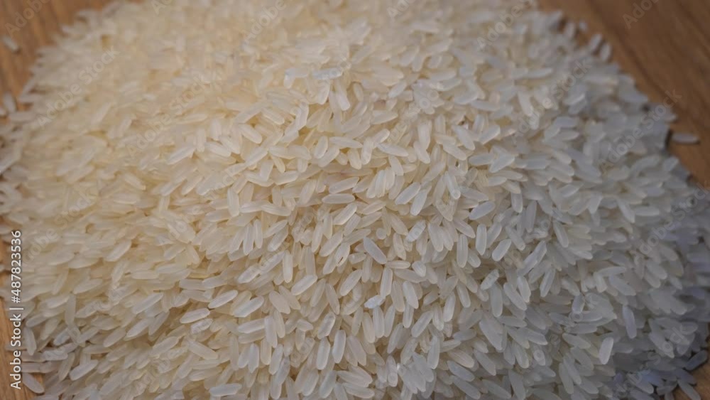 Grains of rice on a rotating wooden surface, top view.
Grains of rice on a rotating wooden surface, top view.