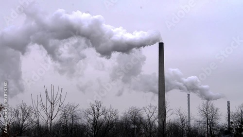 Multiple Factory chimney smoke on a gray day. Monochromatic.