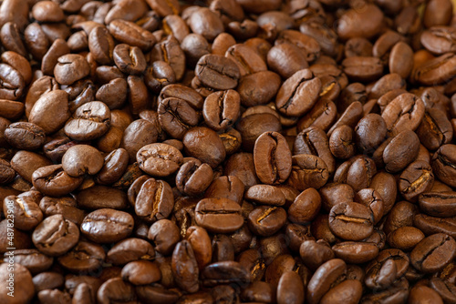 Background of large roasted coffee beans close-up. Macro, soft selective focus.