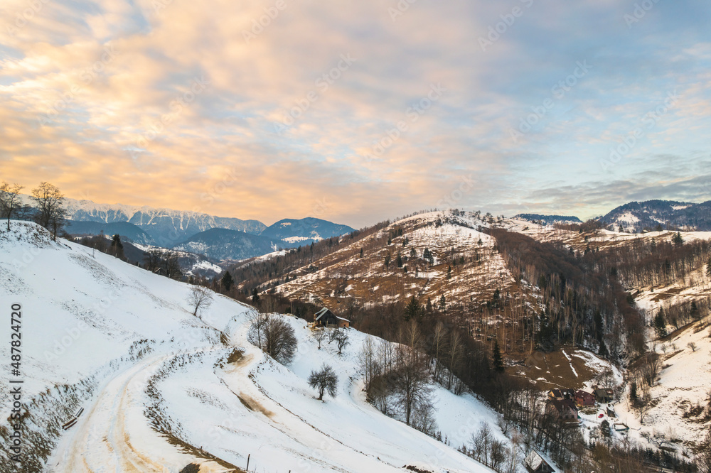 Sunset winter landscape from Transylvania Romania, Pestera Village in search for wilderness, nature, and countryside, along with backcountry road, more people are trying to reconnect with nature