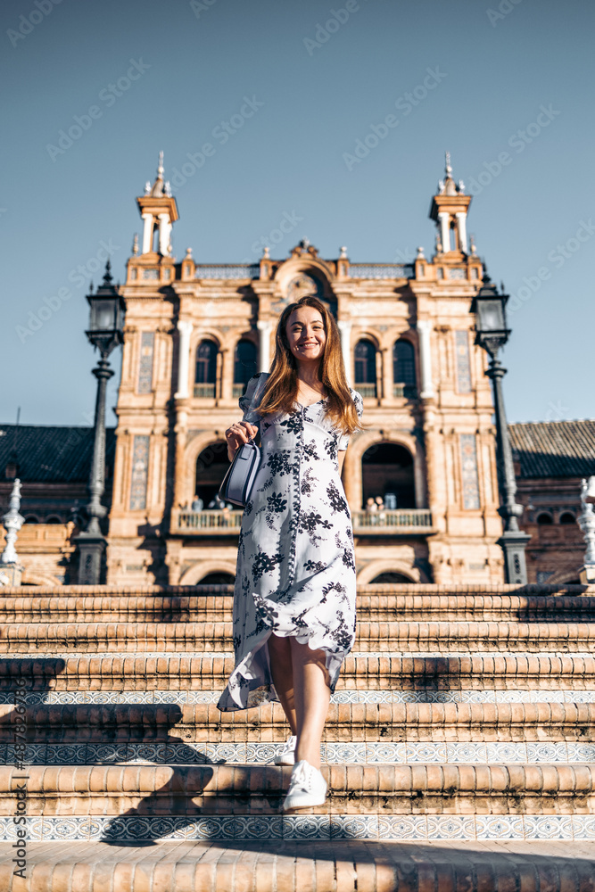 Cheerful smiling pretty woman in summer dress sightseeing in Europe