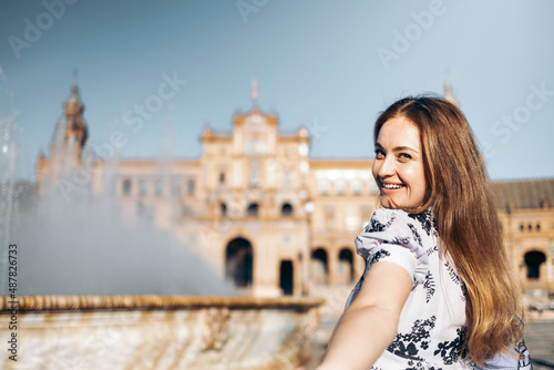 Beautiful smiling young woman holds the viewer's hand sightseeing in Europe. Follow me travel concept. © antoniosantosc